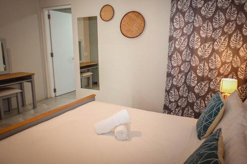a bed with a roll of toilet paper on it at Bois Mapou Self Catering Apartments Unit 203 in Rivière Noire