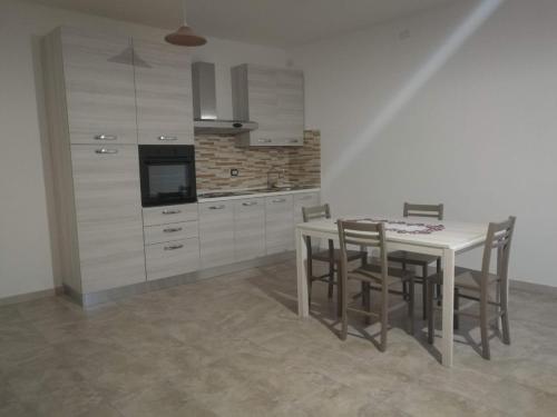 a kitchen with a table and chairs in a room at TreDomus in Iglesias