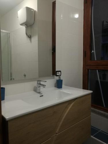 a bathroom with a white sink and a mirror at TreDomus in Iglesias