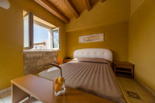a bedroom with a bed with a table and a window at Hotel Casale Milocca in Syracuse