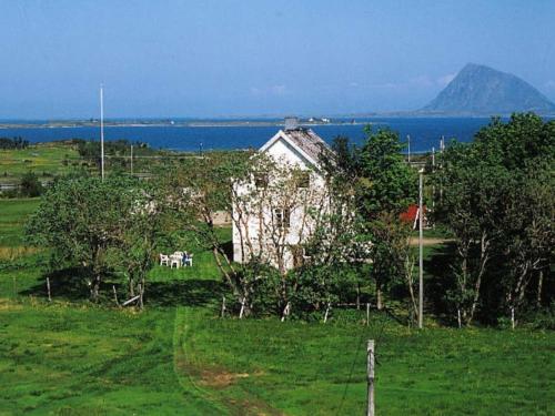 a house in a field with a view of the water at 7 person holiday home in Bøstad in Alstad
