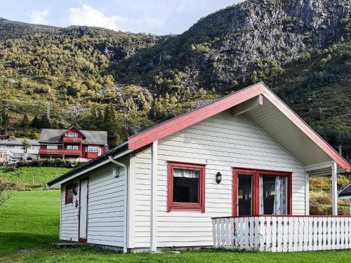 a white house with red windows in front of a mountain at 5 person holiday home in Selje-By Traum in Selje