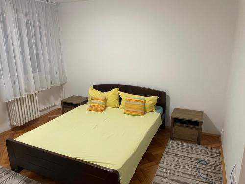 a bedroom with a bed with yellow and orange pillows at Nele in Zrenjanin