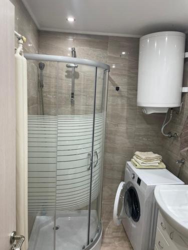 a bathroom with a shower and a washing machine at Nele in Zrenjanin