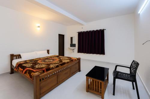 a bedroom with a bed and a chair in it at Hillora Munnar in Munnar