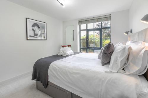 a white bedroom with a large bed with a window at 1 Bed in Lostwithiel oc-n32748 in Lostwithiel