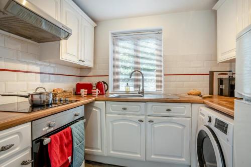 a kitchen with white cabinets and a sink at 2 Bed in Govilon oc-u32754 in Govilon