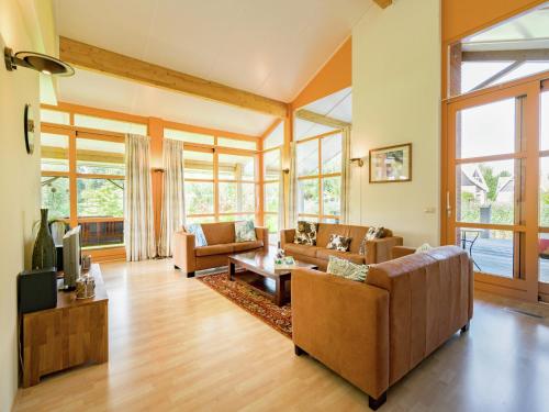 a living room with couches and a tv at Villa in Biddinghuizen by Lake Vulwe in Biddinghuizen