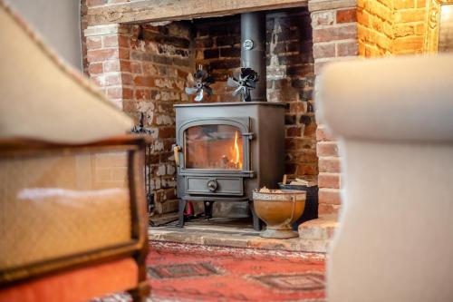 a stone fireplace with a stove in a room at 2 Bed in Dedham oc-c32543 in Dedham