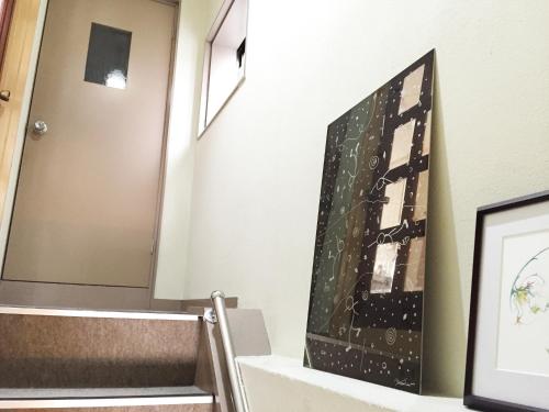 a stairwell with a painting on the wall at Toolate Guesthouse Toyama in Toyama