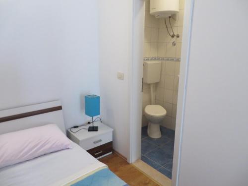 Baño pequeño con cama y aseo en Apartment Frano, en Drače