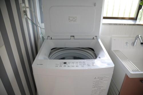 a washer and dryer in a small bathroom at 戸建て貸切宿 サウナ ジャグジー BBQ 最大8名 駐車場2台 HOTEL DREAM MUSIC Minami-Kujūkuri in Shirako