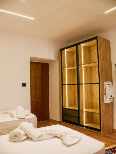 a room with two beds and a glass cabinet at Villa Marie 23 in Gjirokastër