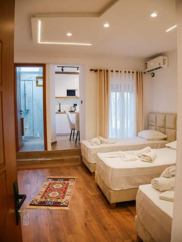 a hotel room with three beds and a kitchen at Villa Marie 23 in Gjirokastër