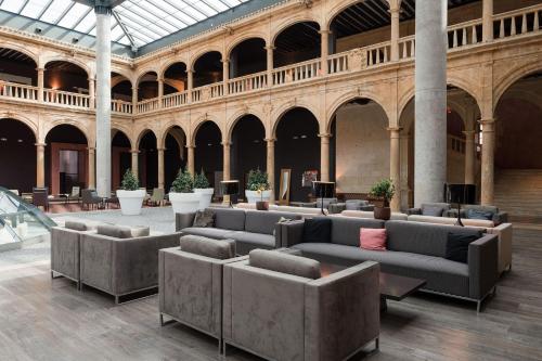 a lobby with couches and tables in a building at Castilla Termal Burgo de Osma in El Burgo de Osma