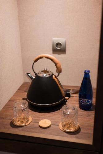 a tea kettle and two glasses on a wooden table at Castilla Termal Burgo de Osma in El Burgo de Osma