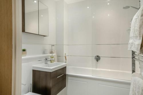 Un baño blanco con lavabo y bañera. en 1 Bed in Freshwater oc-t32758, en Freshwater