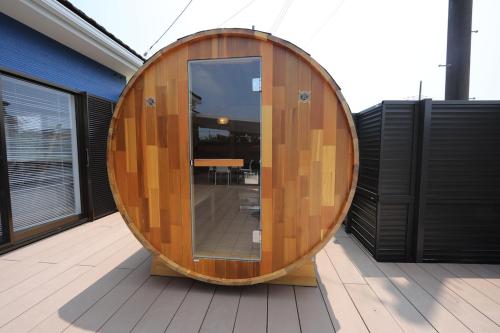 a large wooden barrel sitting on a deck at 戸建て貸切宿 サウナ ジャグジー BBQ 最大8名 駐車場2台 HOTEL DREAM MUSIC Minami-Kujūkuri in Shirako