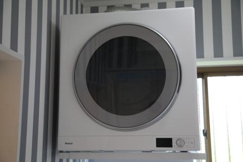 a microwave with a round mirror on top of it at 戸建て貸切宿 サウナ ジャグジー BBQ 最大8名 駐車場2台 HOTEL DREAM MUSIC Minami-Kujūkuri in Shirako