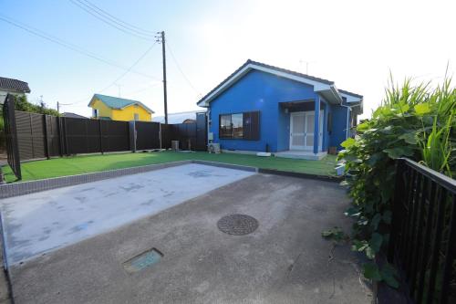 a blue house in a yard with a fence at 戸建て貸切宿 サウナ ジャグジー BBQ 最大8名 駐車場2台 HOTEL DREAM MUSIC Minami-Kujūkuri in Shirako