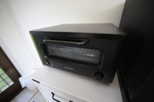 a black toaster oven sitting on top of a counter at 戸建て貸切宿 サウナ ジャグジー BBQ 最大8名 駐車場2台 HOTEL DREAM MUSIC Minami-Kujūkuri in Shirako