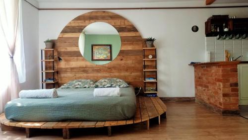 a bedroom with a bed and a circular mirror at Magic Wood Studio Apartament Koniewo in Lidzbark Warmiński