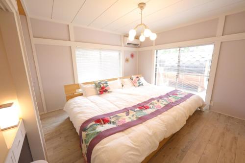 a large bed in a room with a large window at 戸建て貸切宿 サウナ ジャグジー BBQ 最大8名 駐車場2台 HOTEL DREAM MUSIC Minami-Kujūkuri in Shirako