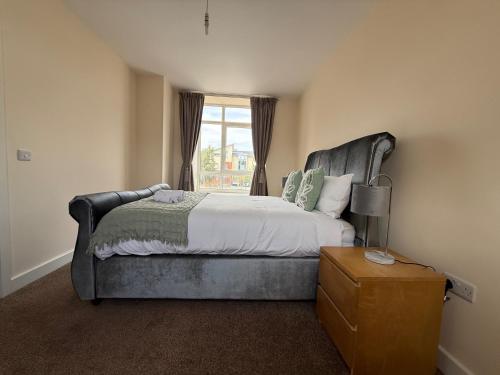 a bedroom with a large bed and a window at Posh Wetheringsett in Milton Keynes in Milton Keynes