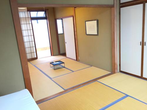 an empty room with a table on the floor at Toolate Guesthouse Toyama in Toyama