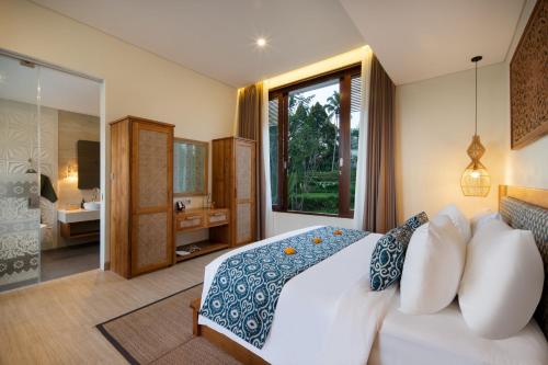 a bedroom with a large bed and a bathroom at Khastana Hadi Tegallalang, Ubud in Tegalalang