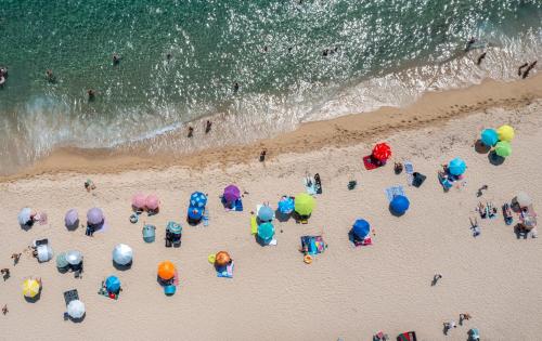 a group of people on a beach with umbrellas at BLUE HORIZON SARTI Oe in Sarti