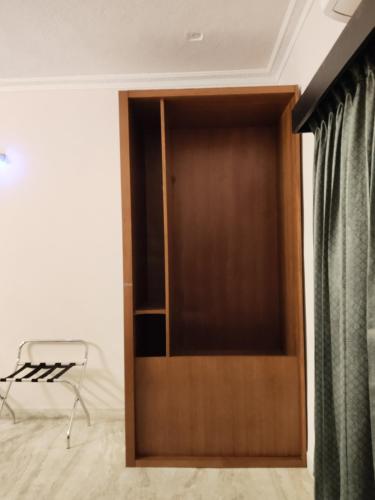 a wooden door in a room with a chair at Umino Beach House in Covelong