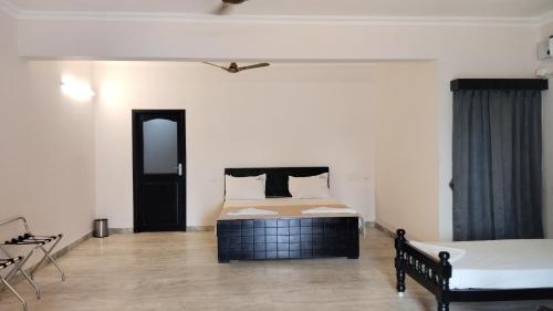 a white room with a bed and a table at Umino Beach House in Covelong