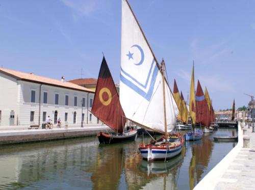 a group of sailboats are docked in a canal at Miramare in Cesenatico