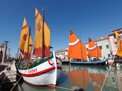 three small sailboats are docked in a harbor at Miramare in Cesenatico