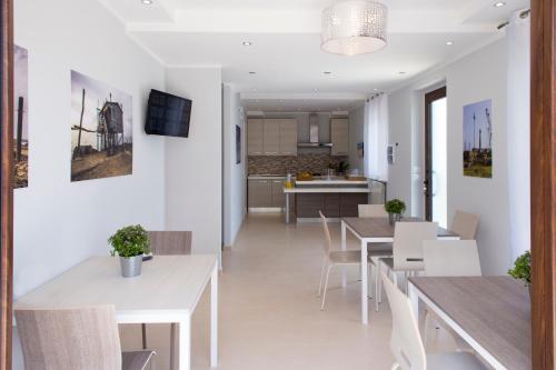 a dining room and kitchen with white tables and chairs at B&B OLGANNA con Parcheggi privati in Vasto