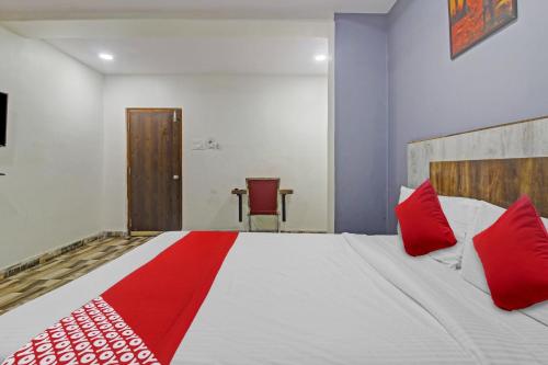 a bedroom with a large bed with red pillows at Hotel O Sri Sai Regency in Hyderabad