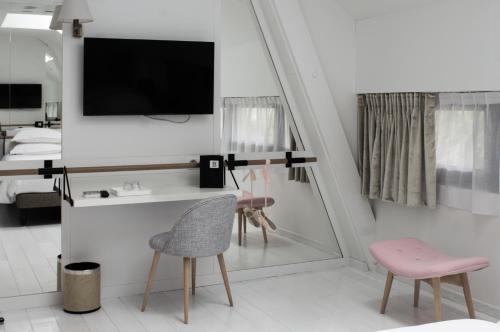 a bedroom with a desk and a mirror and a pink chair at Le Magic Hall in Rennes