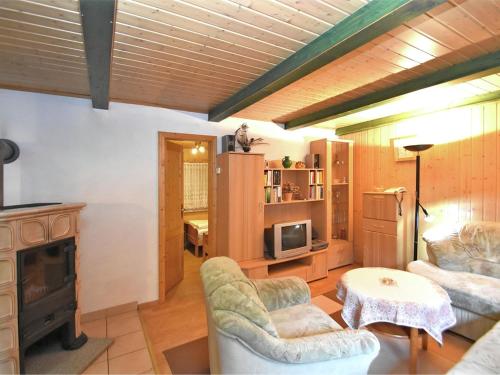 a living room with two chairs and a fireplace at Welcoming bungalows in Neustadt in Neustadt/Harz