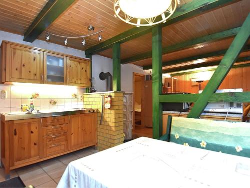 a large kitchen with wooden cabinets and a table in it at Welcoming bungalows in Neustadt in Neustadt/Harz