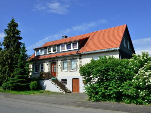 a white house with an orange roof at Apartment in the Hochsauerland region in a quiet location in Stormbruch