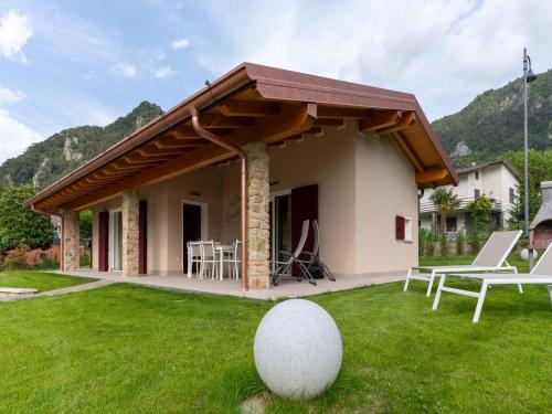 a house with a wooden roof and a green lawn at Idyllic cottage next to the beautiful Lake Idro in Crone
