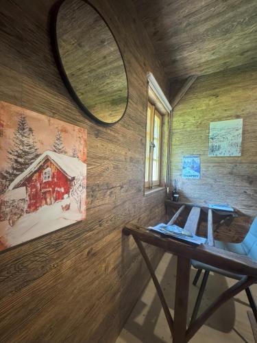 a room with a wooden wall with a table and a mirror at La Chotte du Musher in Champéry