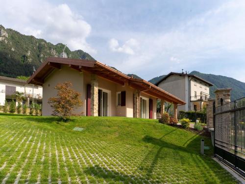 a house with a green yard with a fence at Idyllic cottage next to the beautiful Lake Idro in Crone