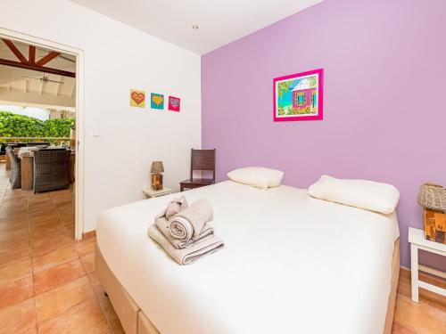 een slaapkamer met een wit bed met handdoeken erop bij Holiday villa at Jan Thielstrand in Willemstad in Jan Thiel