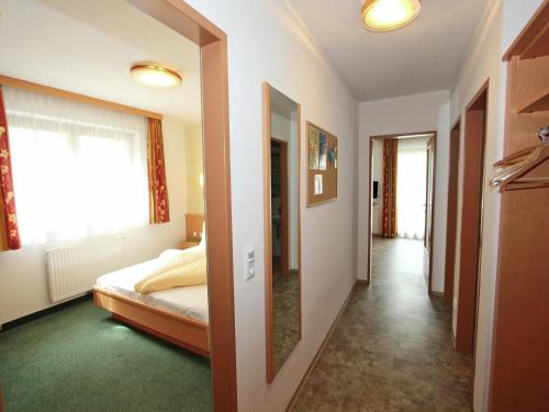 a hallway with a bed and a mirror in a room at Attractive holiday home in Kaltenbach on the ski-slope in Stumm
