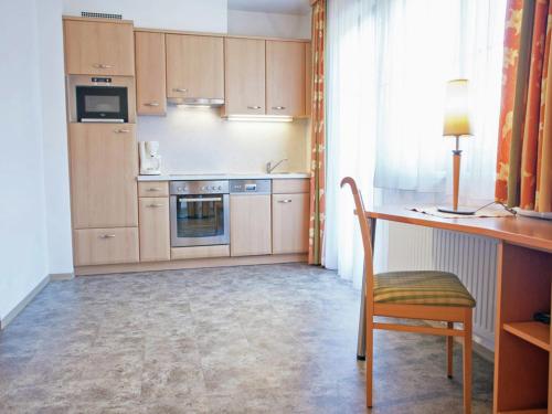 a kitchen with wooden cabinets and a table and a chair at Attractive holiday home in Kaltenbach on the ski-slope in Stumm