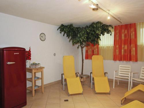 a room with yellow chairs and a table and a tree at Attractive holiday home in Kaltenbach on the ski-slope in Stumm