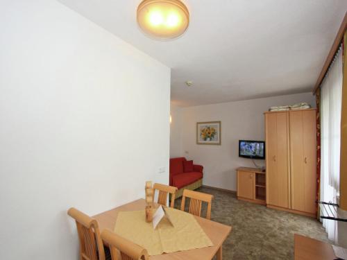 a dining room with a table and a red couch at Attractive holiday home in Kaltenbach on the ski-slope in Stumm