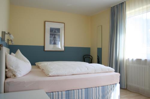 a bedroom with a bed with a blue accent wall at Seewiese 01 Seeblick mit Hochschwarzwald-Card in Titisee-Neustadt